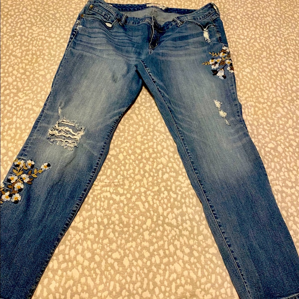 Torrid jeans with decorative embroidered flowers.